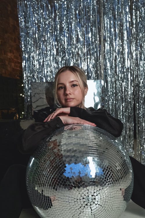 Woman leaning on a Disco Ball 