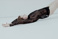 Woman in Black Lace Shirt Laying on Back on Floor with Hips Up