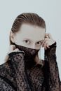Blond Young Woman with Face Partly Covered with Lace Fabric