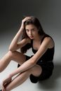 Woman in Black Tank Top and Black Shorts Sitting on White Floor