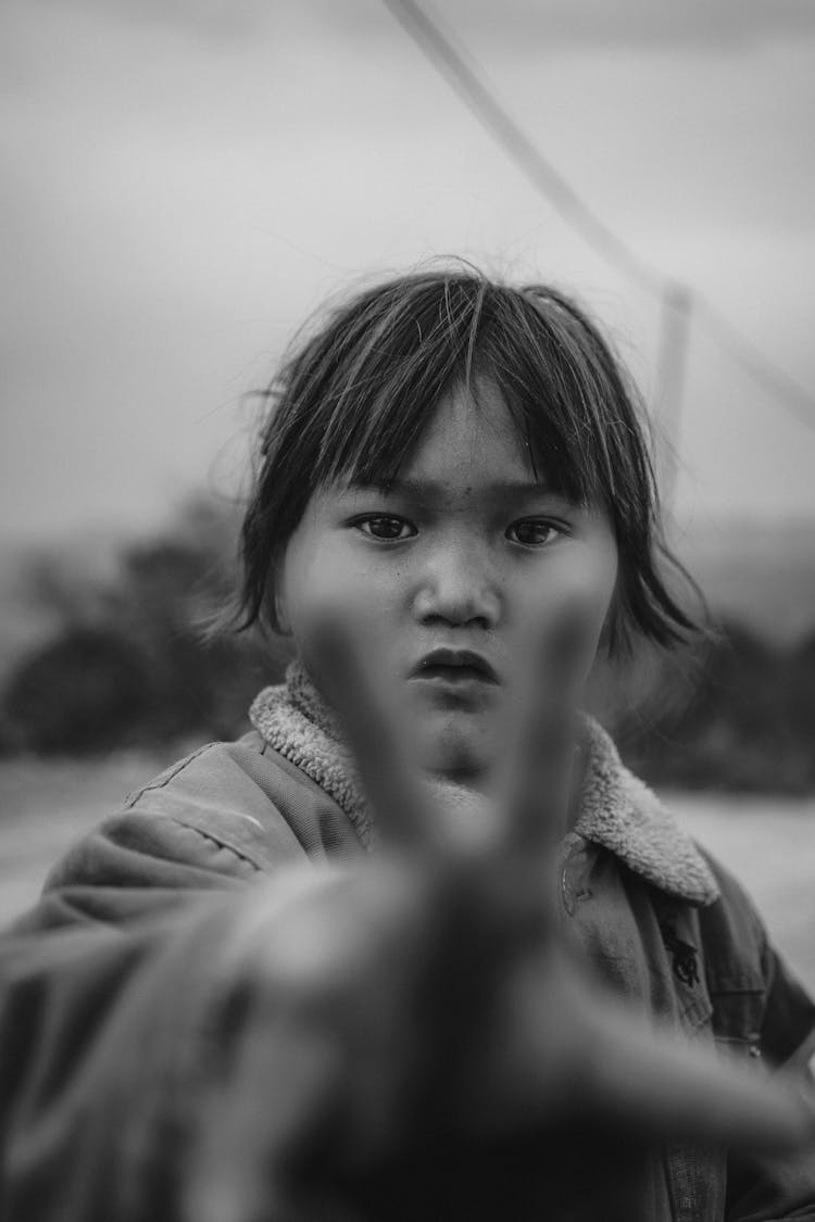 Black And White Portrait Of Child Reaching Out Towards Camera