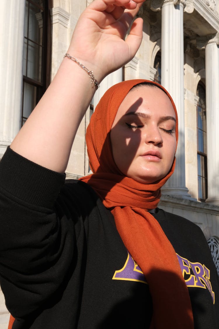 Hijabi Woman Shielding From Sun With Hand