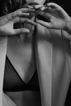 Black and white artistic portrait of a woman in lingerie and blazer.