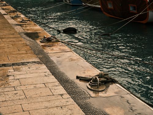 Free Dockside marina with ropes and docked boats, offering a serene maritime atmosphere. Stock Photo