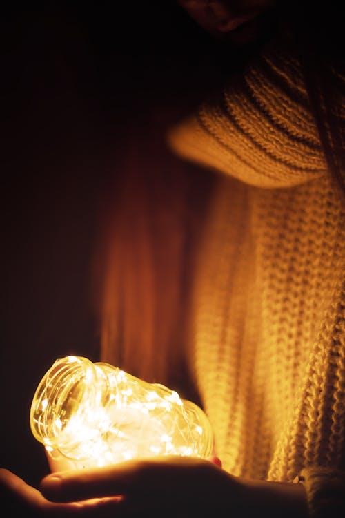 A Close-Up Shot of a Person Holding a Gar with Fairy Lights