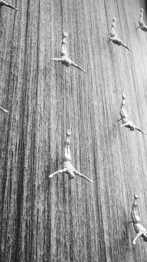 Free Artistic diver sculptures cascade in Dubai Mall's iconic waterfall installation. Stock Photo