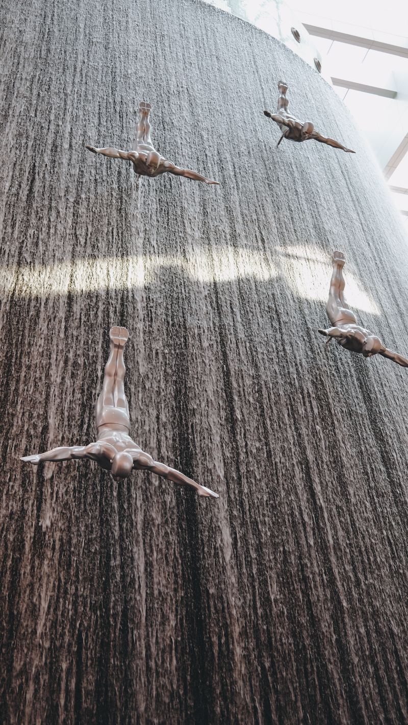 Indoor waterfall with silver diver sculptures inside the Dubai Mall