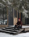 Man in Beanie Sitting on Treshold