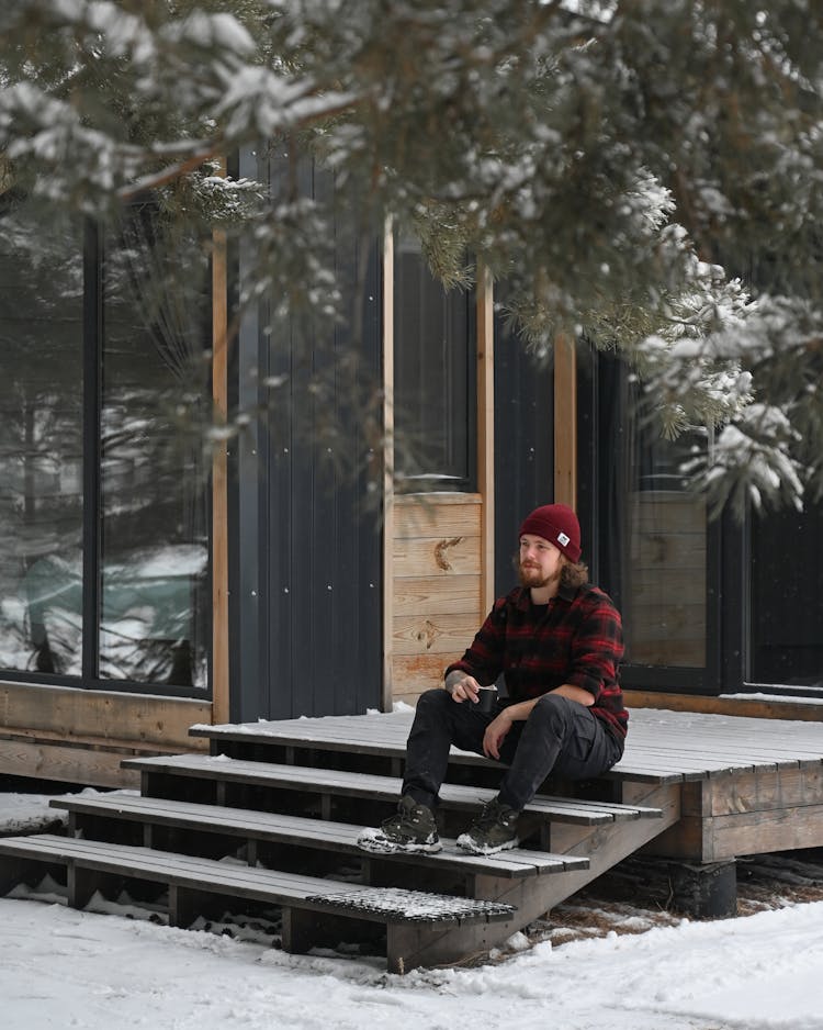 Man In Beanie Sitting On Treshold