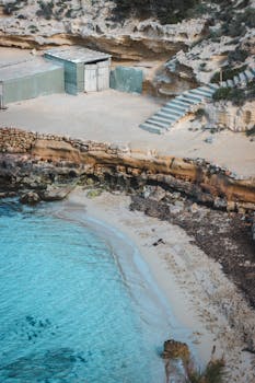 A tranquil rocky beach with aqua blue waters in Sant Josep de sa Talaia, Spain, perfect for relaxation.