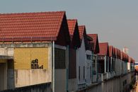A lineup of urban buildings featuring red tiled roofs in an outdoor city setting.