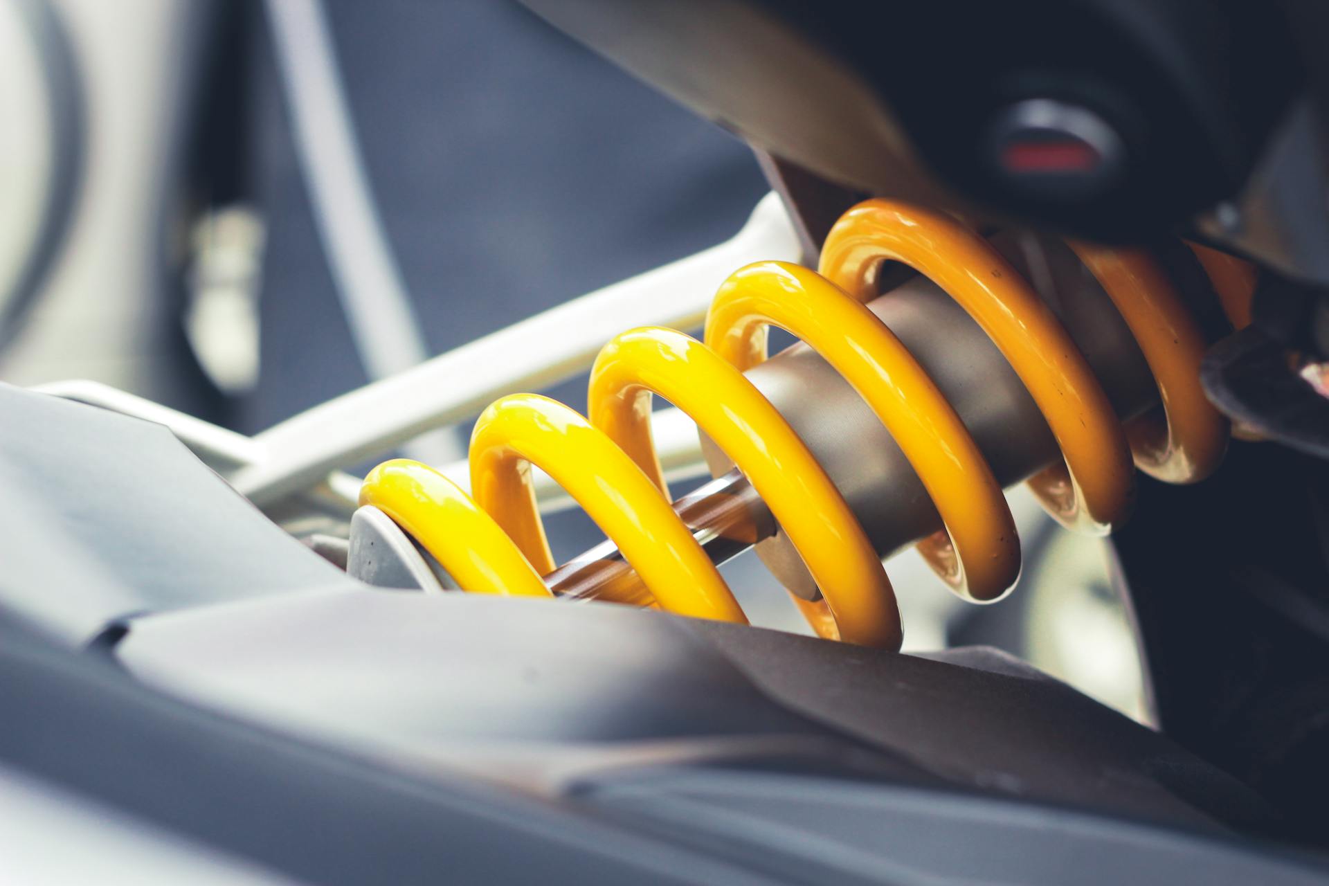 Close-up of a vibrant yellow coil spring, showcasing mechanical engineering details.