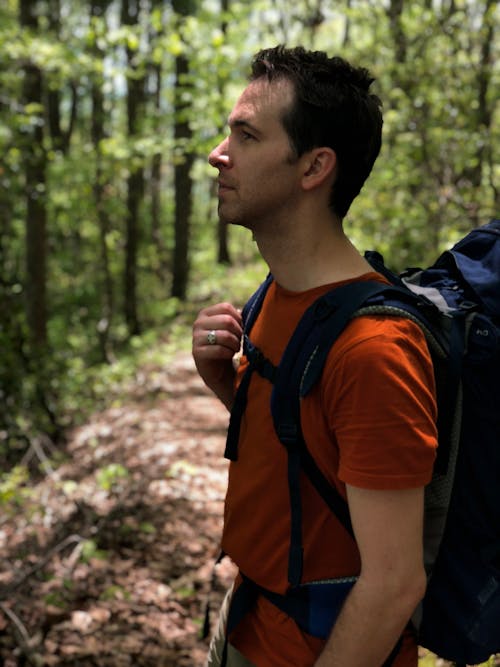 Man in Red Crew-neck Shirt Carrying Blue Hiking Backpack