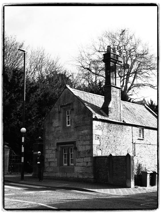 Grayscale Photo of Brick House Near Street Light