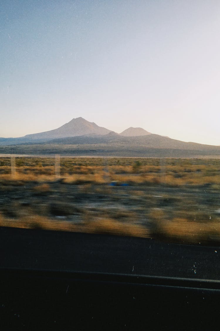 Photograph Of Distant Mountain Peaks Shot From Fast Moving Vehicle