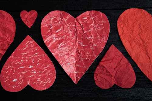 Red Heart Shaped Paper on Brown Wooden Table