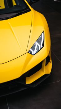 Detailed view of a modern yellow sports car's sleek design and headlight.