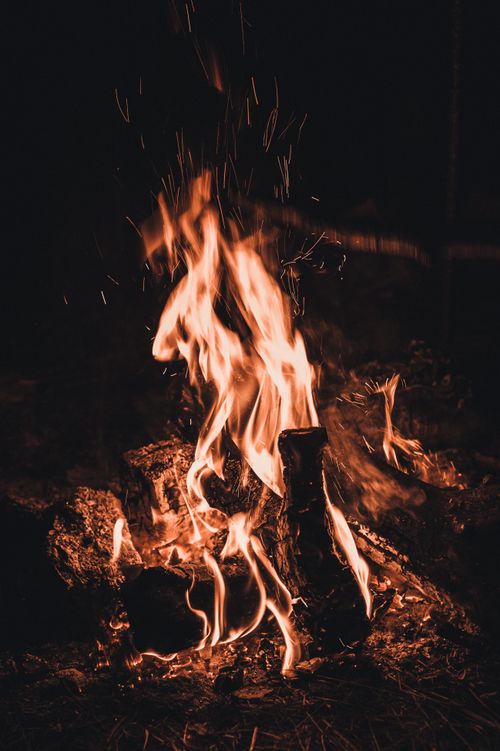 Free Close-up of a vibrant campfire at night with dynamic swirls of flame and sparks. Stock Photo