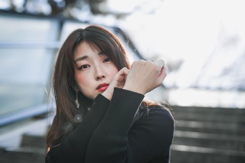 Free Beautiful portrait of an east Asian woman posing outdoors with soft lighting. Stock Photo