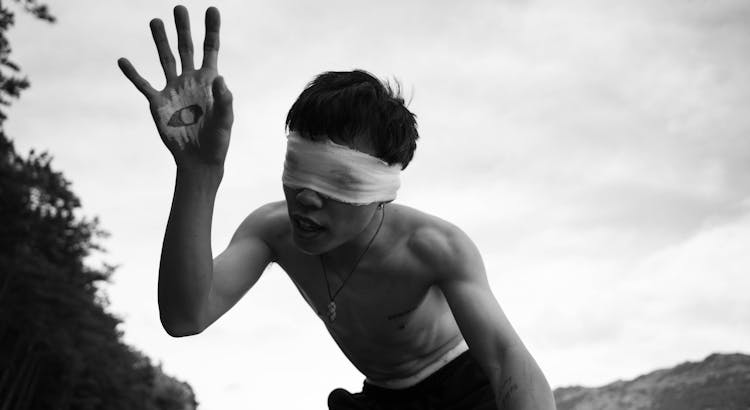 Black And White Photo Of A Man Performing With Blindfolded Eyes