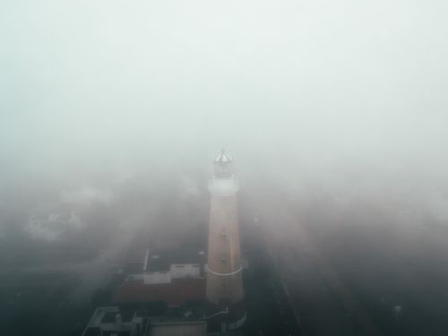 Free A mesmerizing aerial view of the Punta del Este Lighthouse shrouded in thick fog, creating a mysterious ambiance. Stock Photo