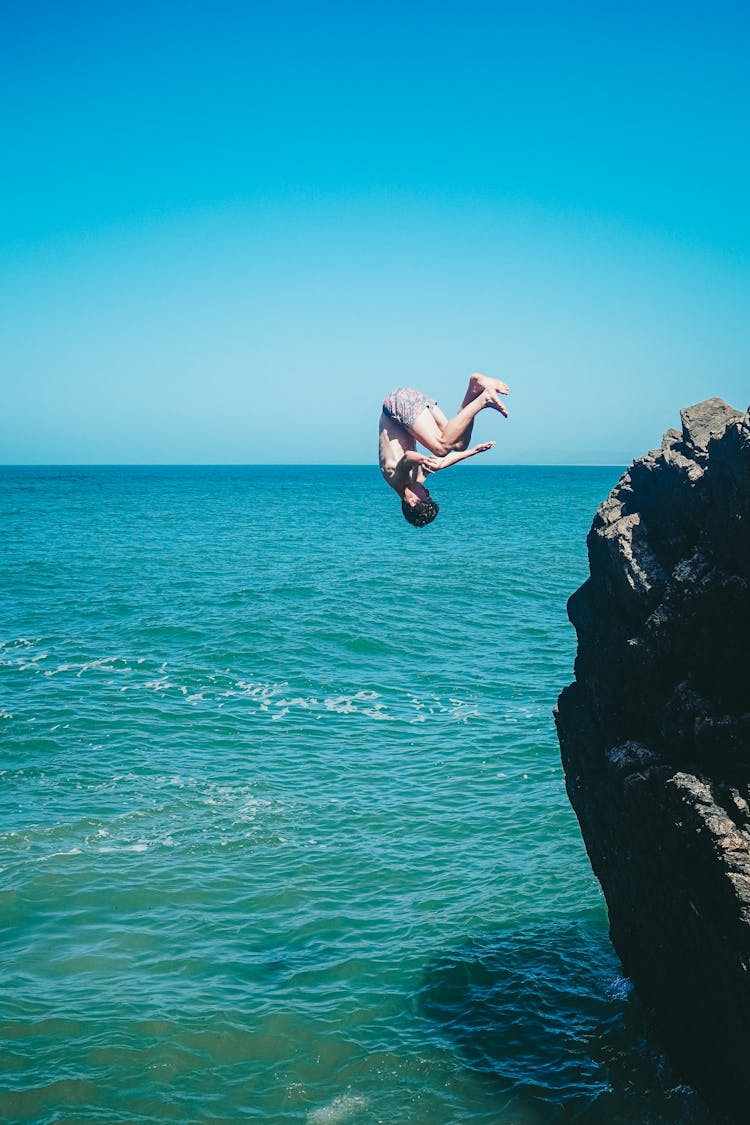 A Shirtless Man Diving On The Sea