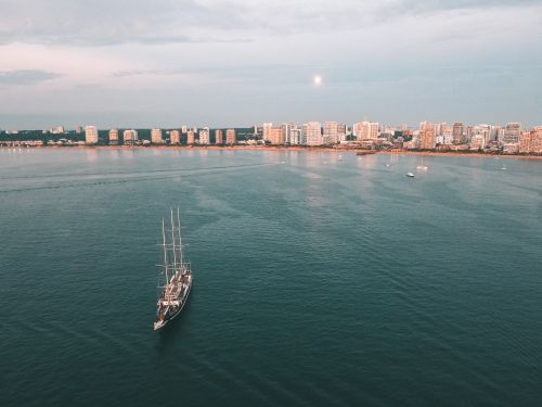 Free Stunning aerial photo of Punta del Este's coastline with a sailboat and skyline at sunset, Uruguay. Stock Photo