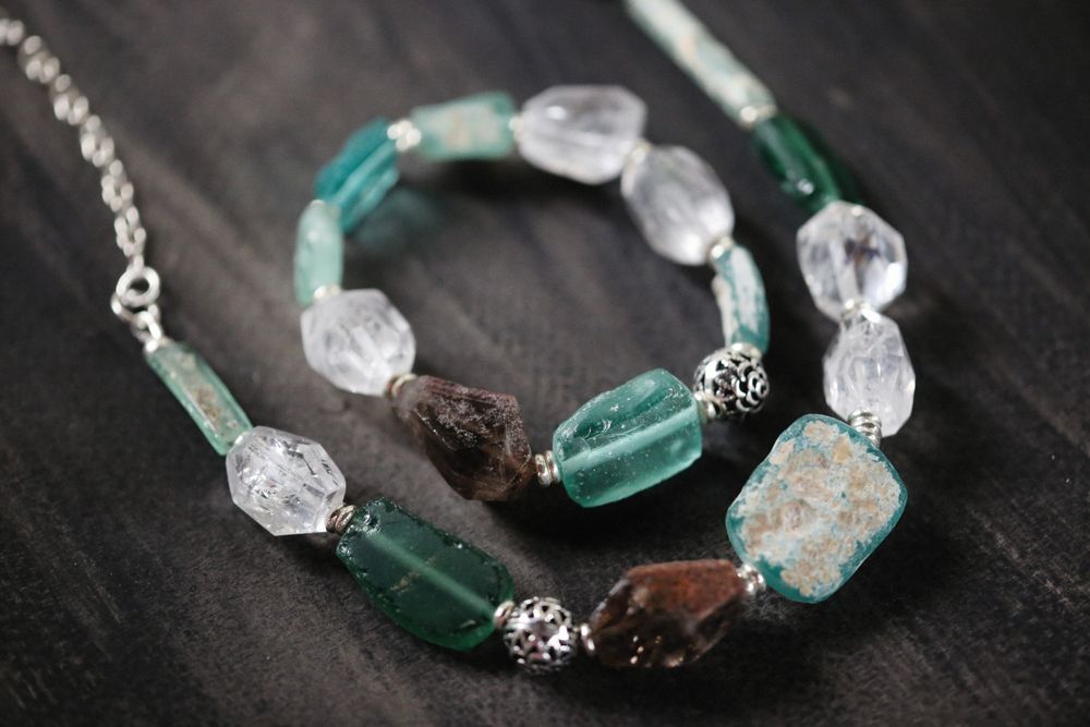 Ketting en armband van gepolijste half-edelstenen op een lichte ondergrond