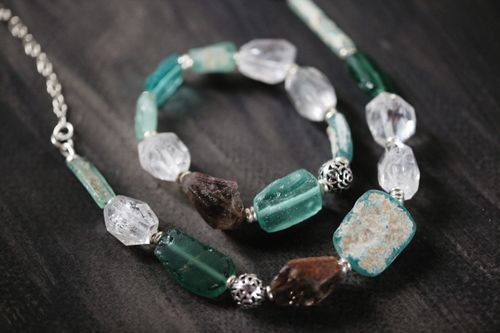 Free Close-up of a beautiful gemstone necklace and bracelet set on a dark wooden background. Stock Photo