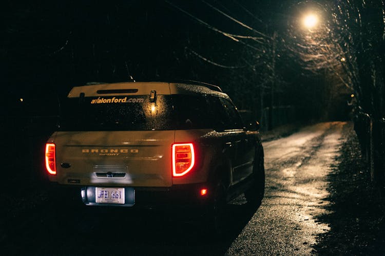 A White Ford Bronco Sport On The Road At Night