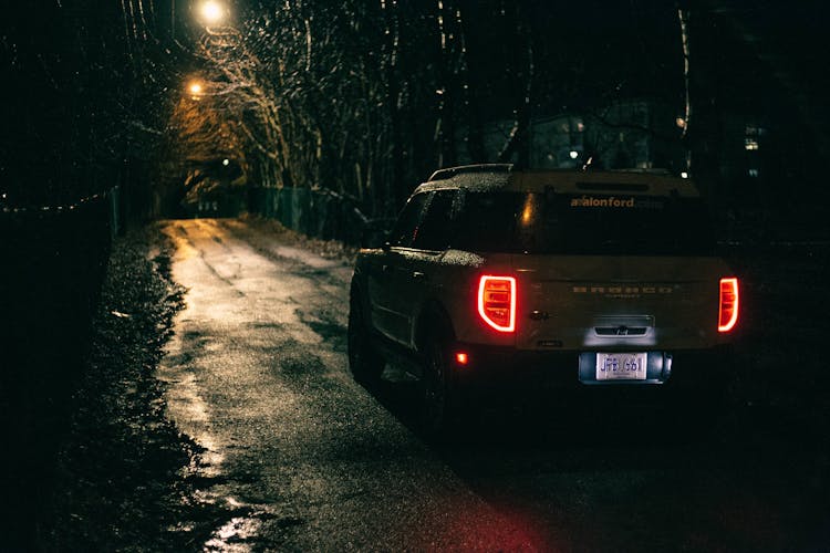 A White Ford Bronco Sport On The Road At Night