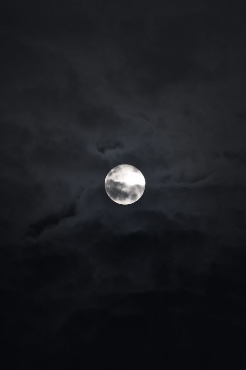 Free Captivating full moon illuminating the dark night sky with scattered clouds. Stock Photo