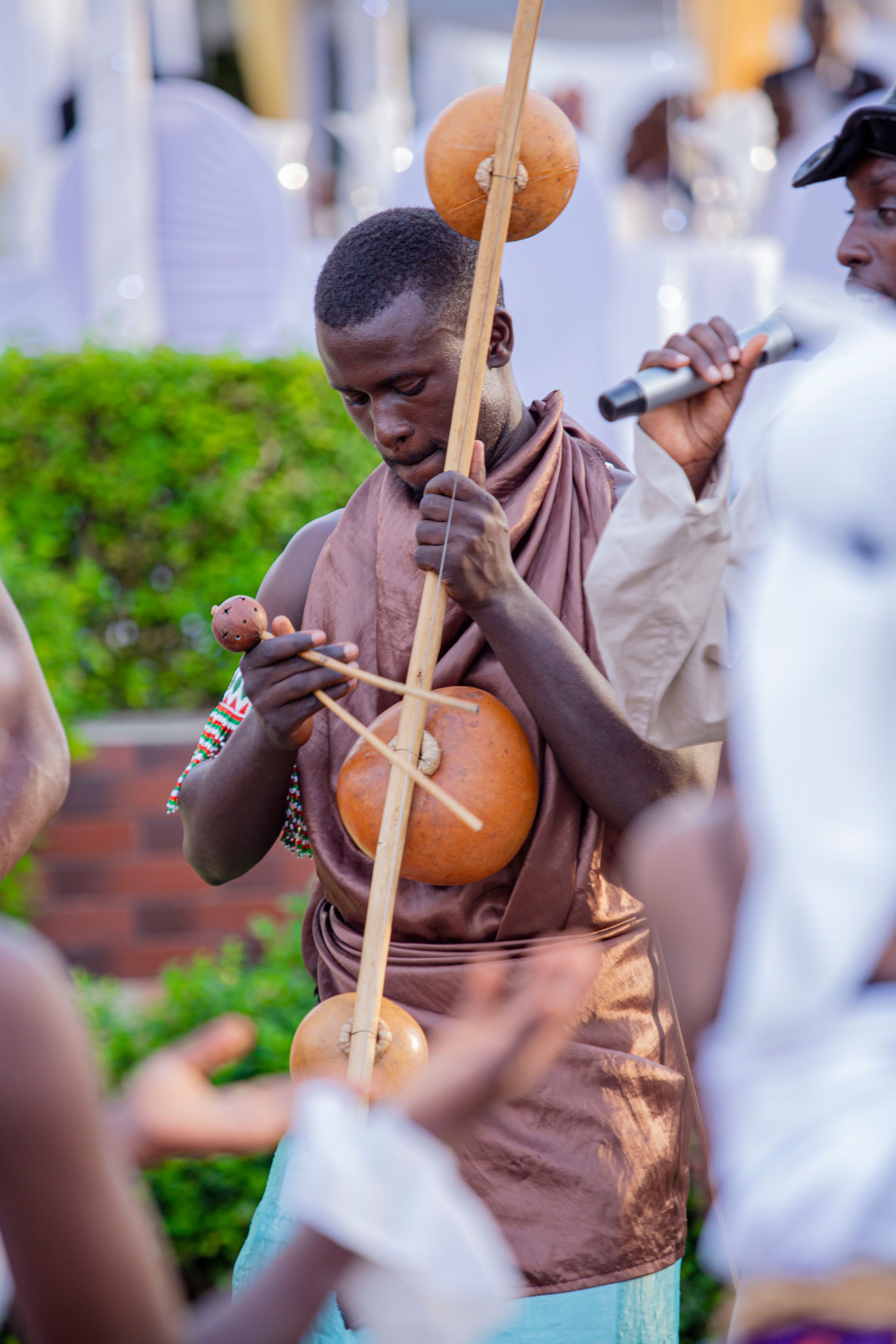 Portrait of a musician playing the berimbau at a cultural celebration outdoors.