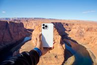 Person Holding White Smartphone Taking Photo of Brown Rock Formation