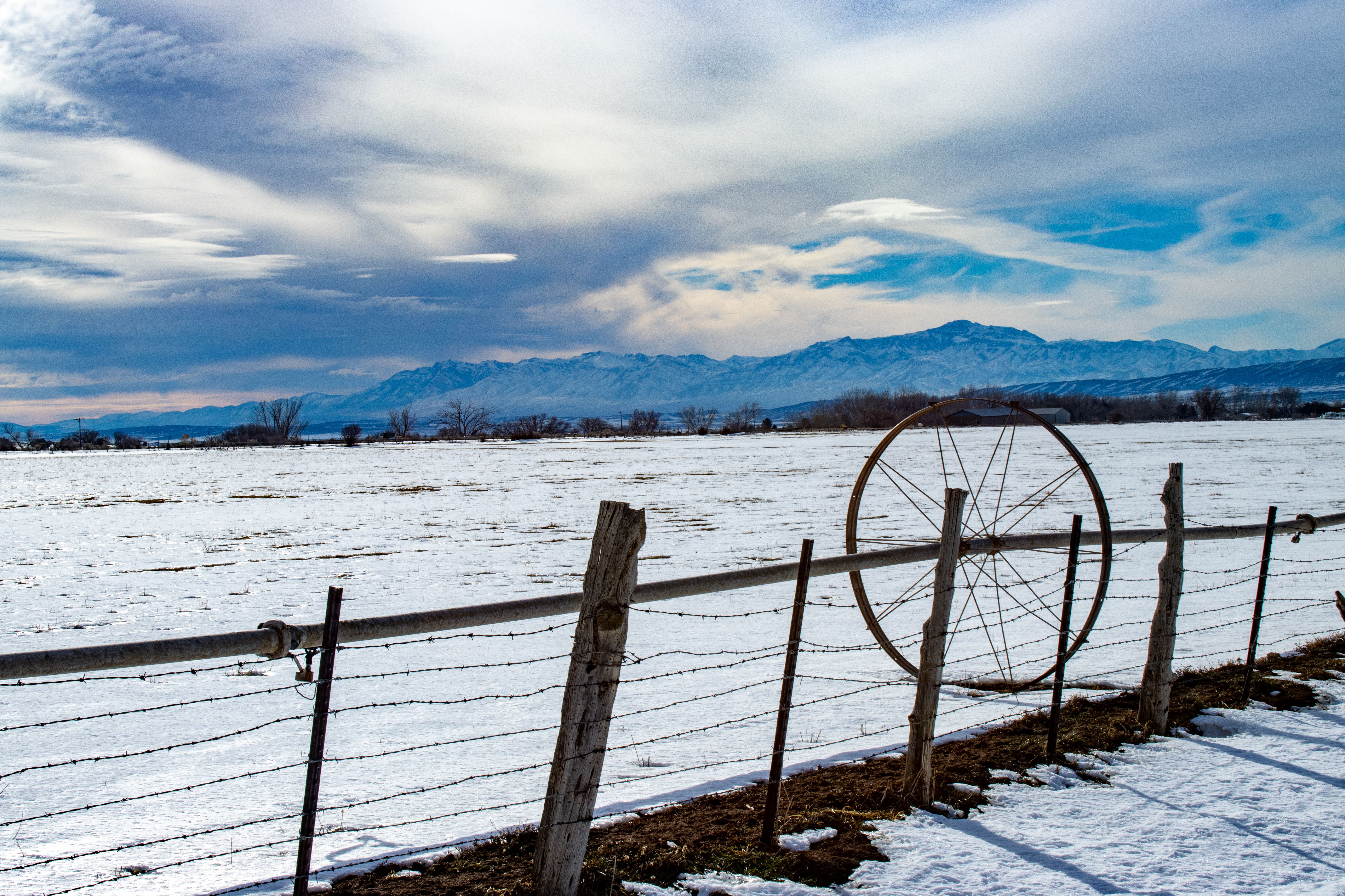 A serene winter scene showcasing a snowy field with distant mountains in Levan, Utah.