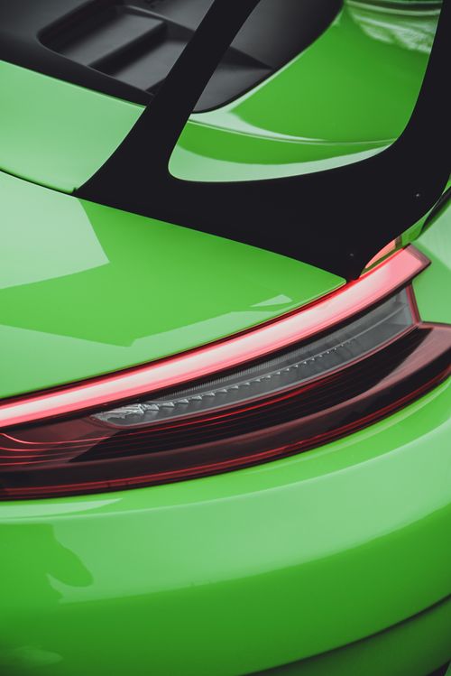 Free Close-up shot of a green sports car's taillight with aerodynamic spoiler in daylight. Stock Photo