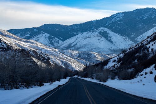 Free Scenic View of a Road near the Snow Covered Mountains Stock Photo
