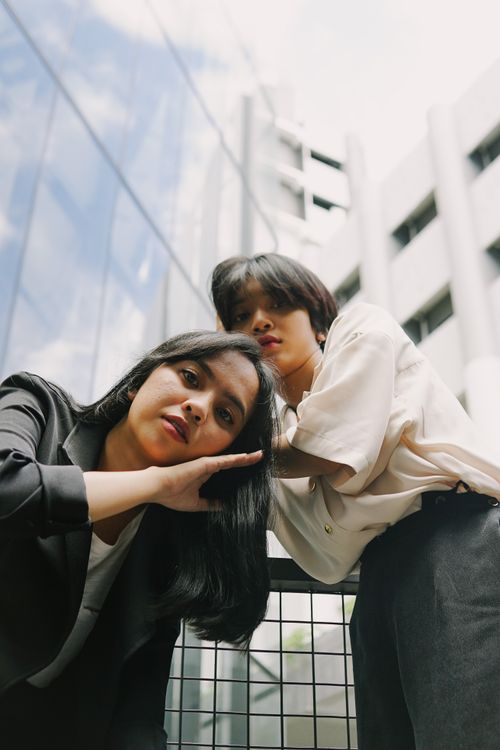 Free Stylish young women in modern urban setting, posing creatively outdoors. Stock Photo