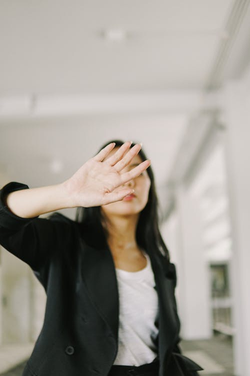 Woman in a Black Blazer Covering Her Face