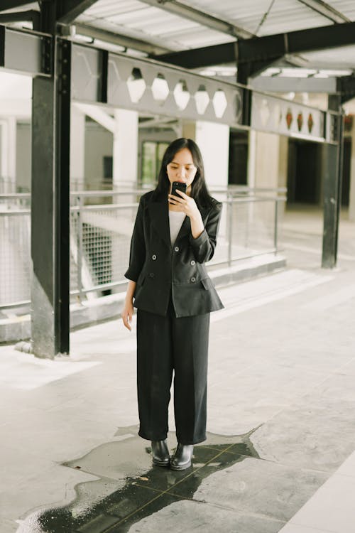 Woman in Black Blazer Using a Cellphone