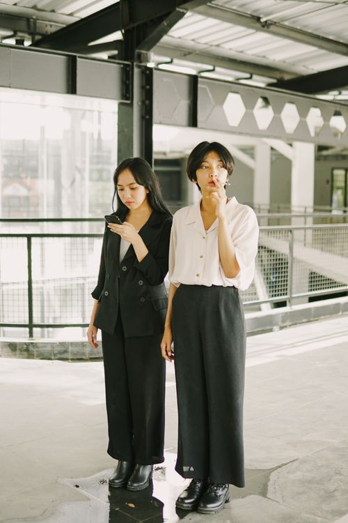 Free Two women pose in minimalist fashion in an urban setting, showcasing modern style. Stock Photo