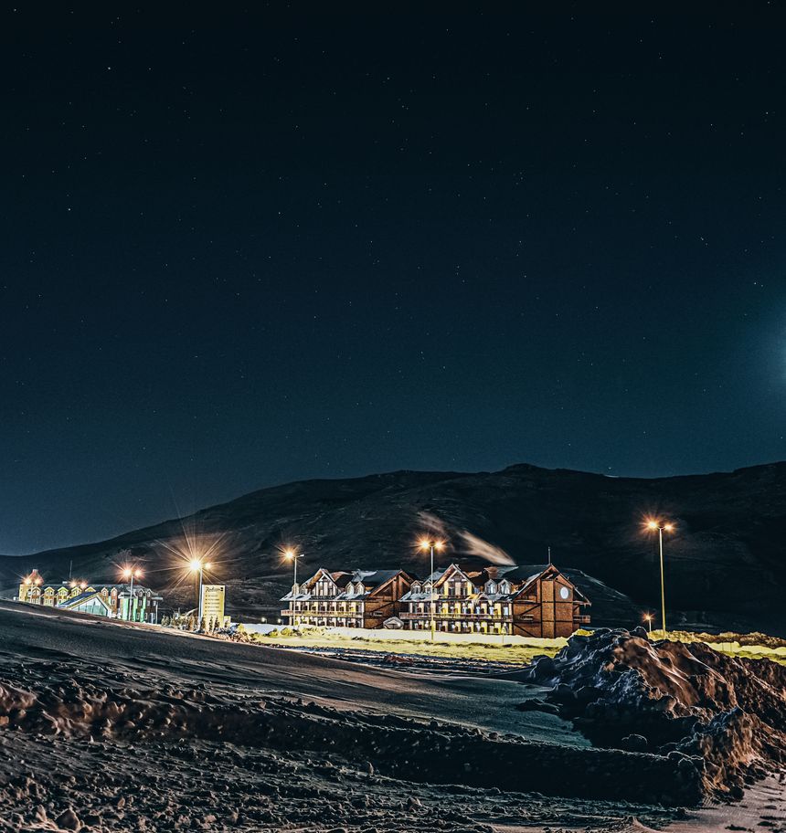 Village under a starry sky below snow-covered mountains — photo by Emir Anık on Pexels