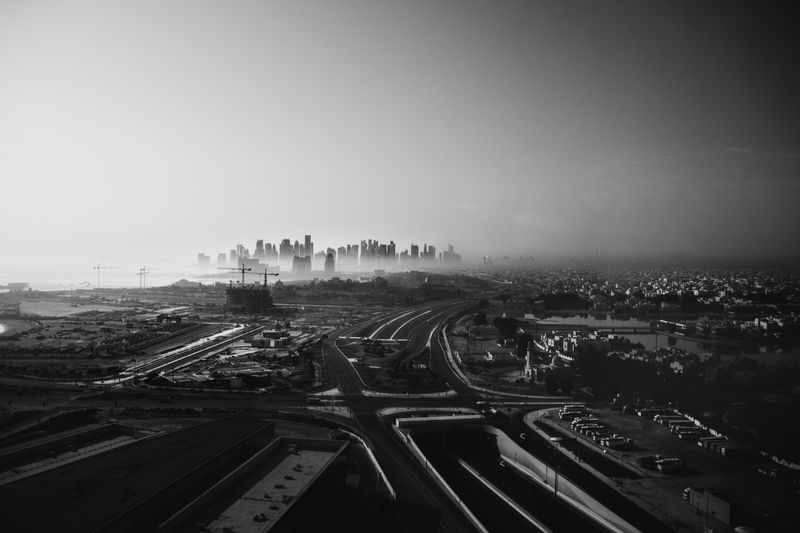 Aerial view of a vast urban cityscape with towering skyscrapers in monochrome.
