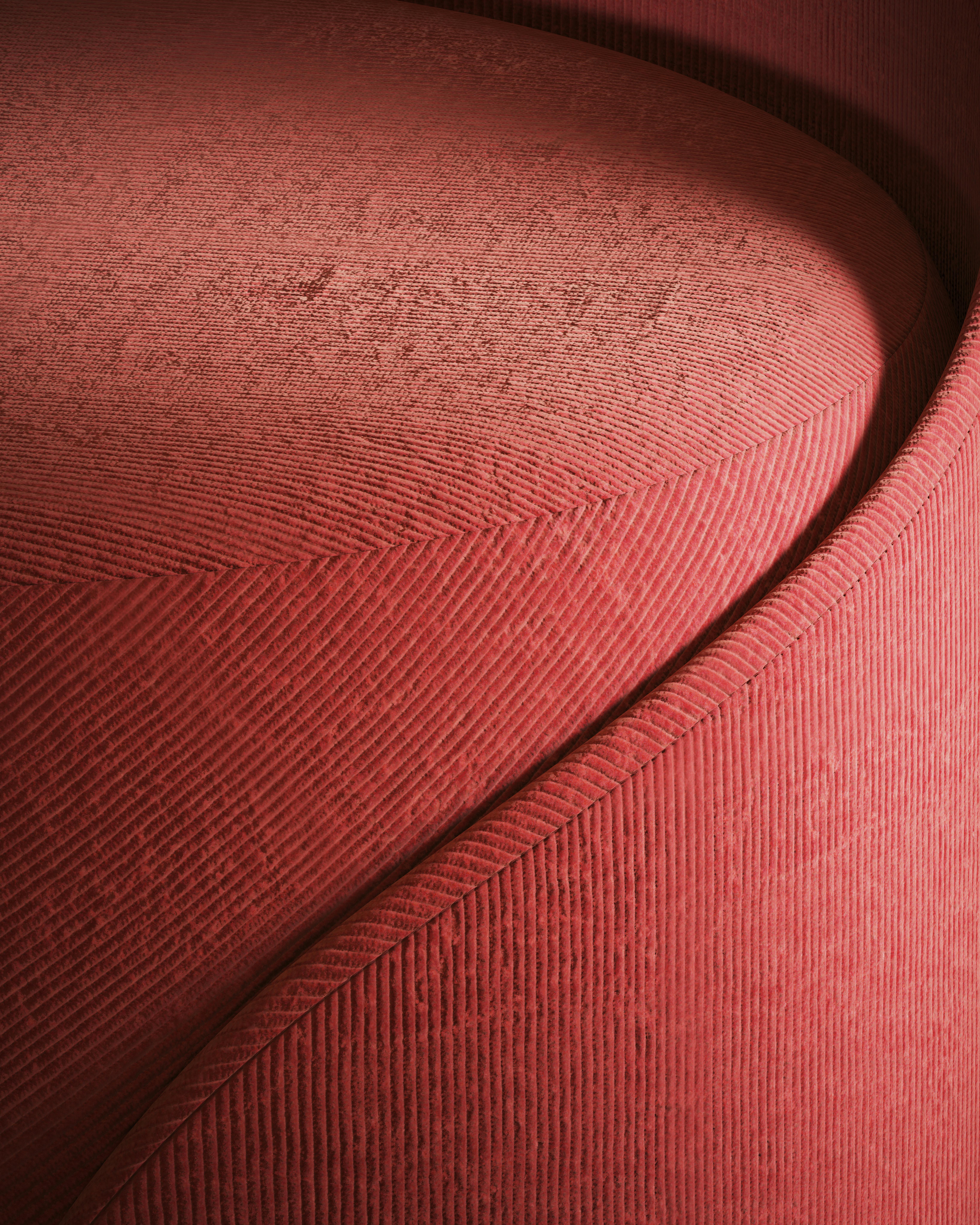 Detailed view of a red sofa with distinctive fabric texture and curves.