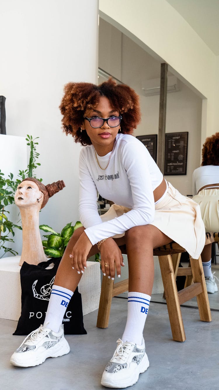 Woman With Red Curly Hair In Glasses Sitting With Her Back To Mirror