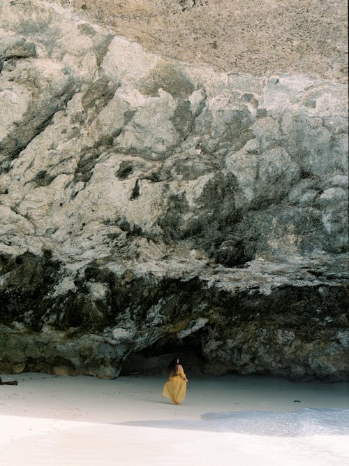 Woman in Yellow Dress Walking into Cave 