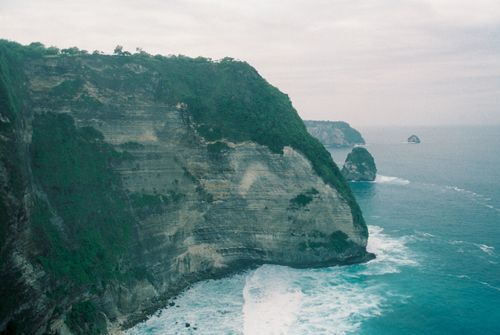 Free A stunning aerial view of Bali's coastal cliffs, showcasing the dramatic sea and lush vegetation. Stock Photo