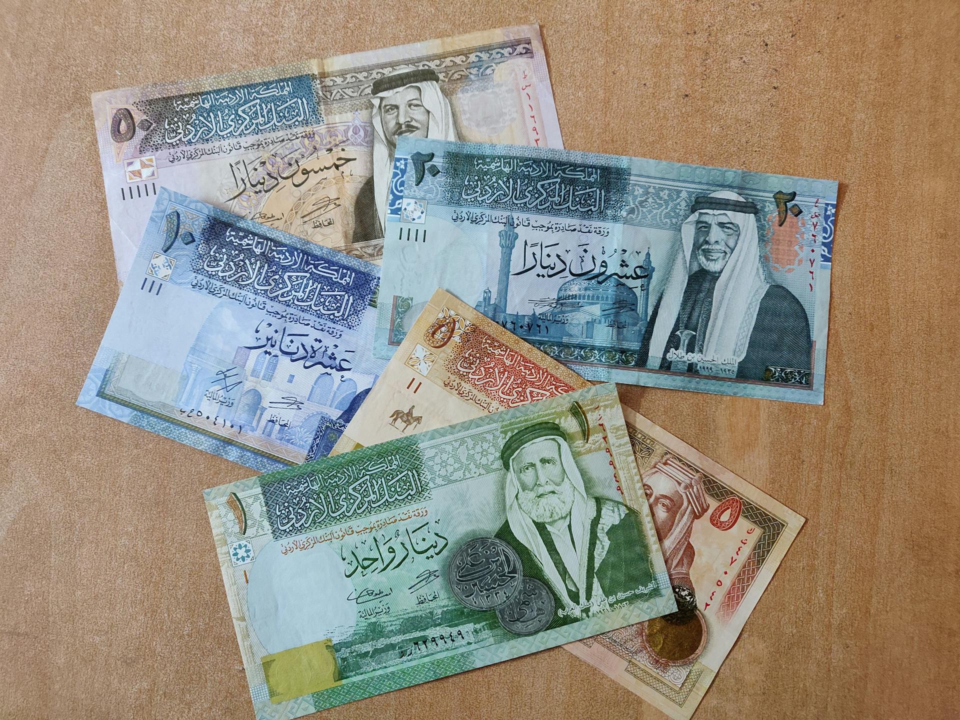 A collection of diverse Jordanian banknotes laid out on a surface, showcasing various denominations.