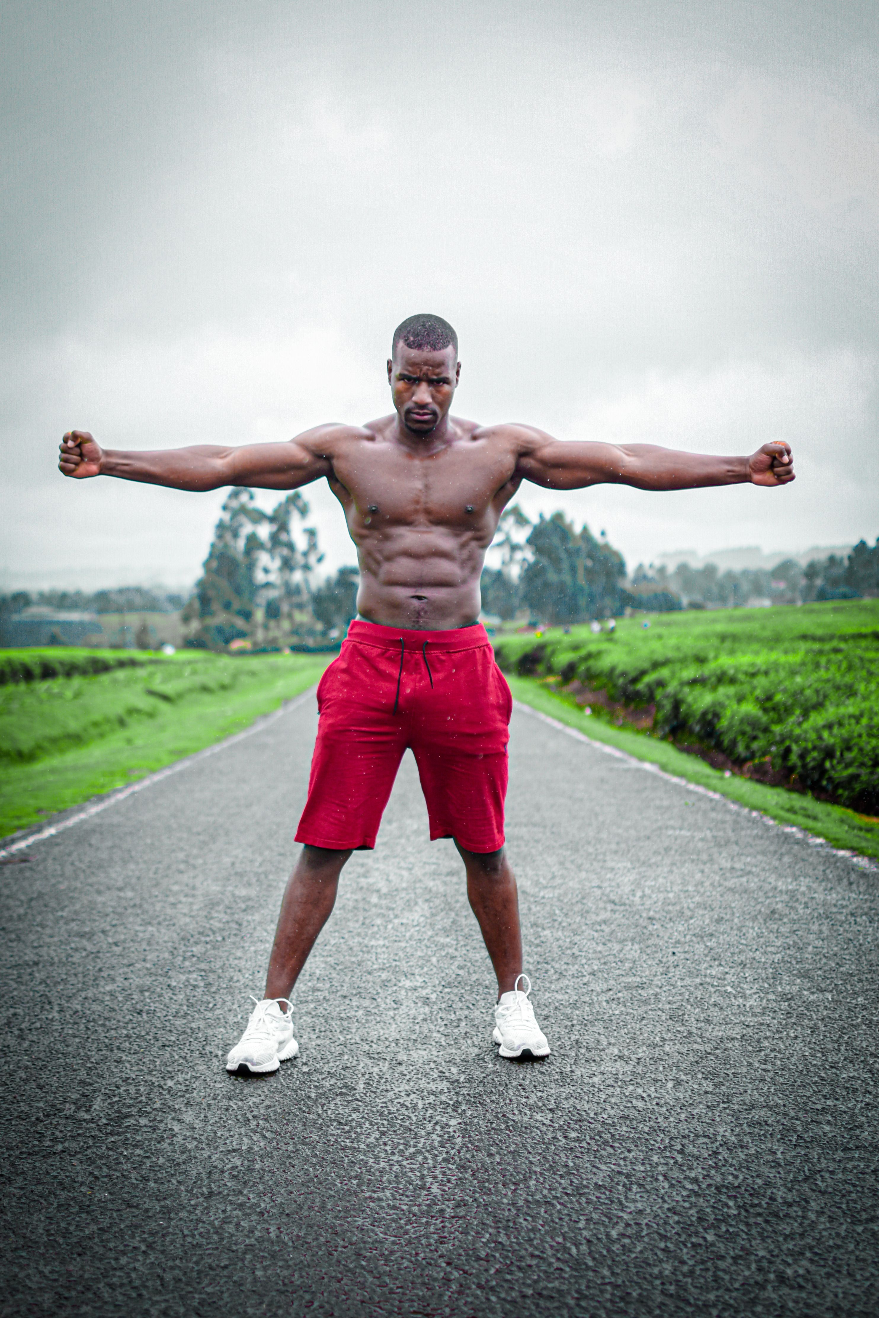 Shirtless man posing confidently on a road in Limuru, embracing fitness and strength.