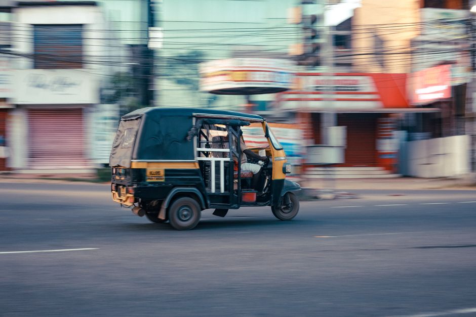 A fast-moving auto rickshaw captures the essence of urban transportation.